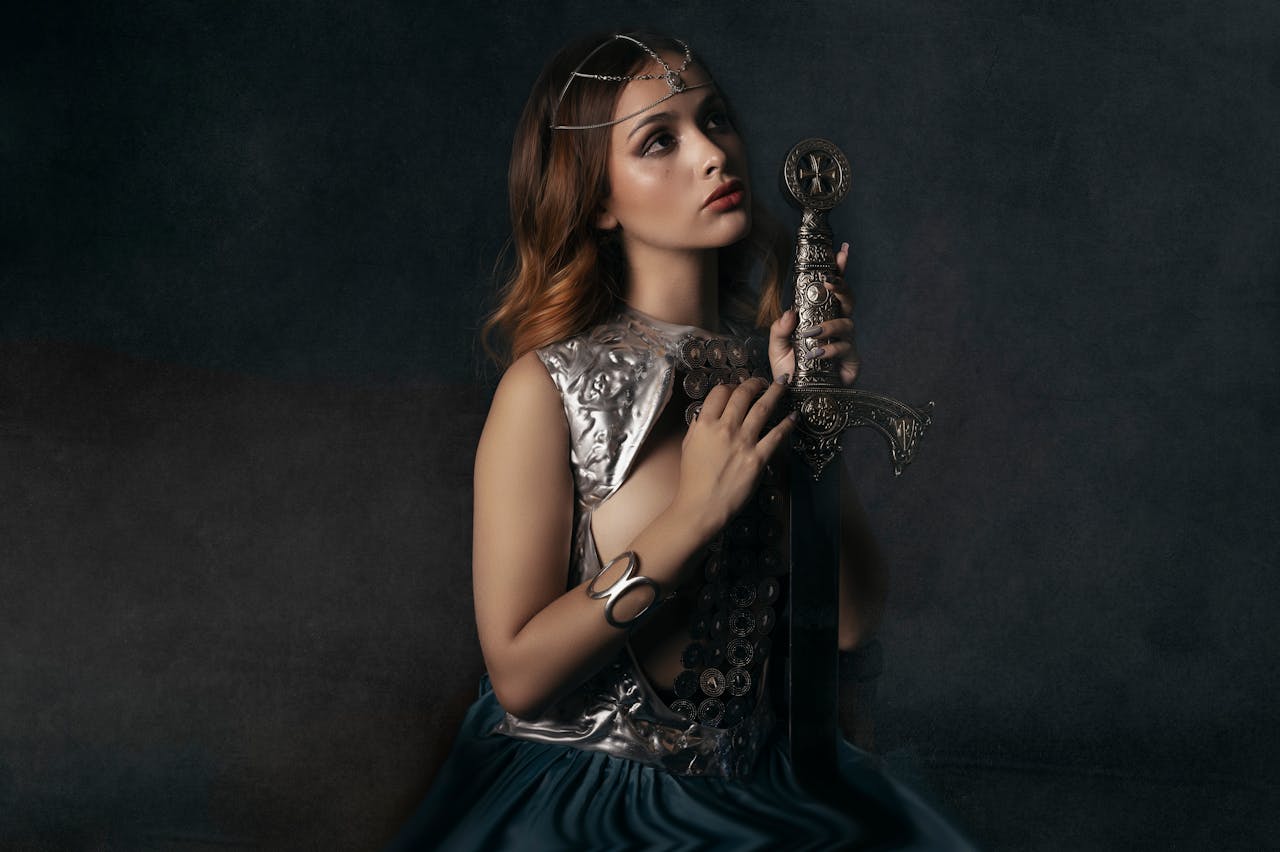 Portrait of a woman in medieval attire holding a decorative sword.