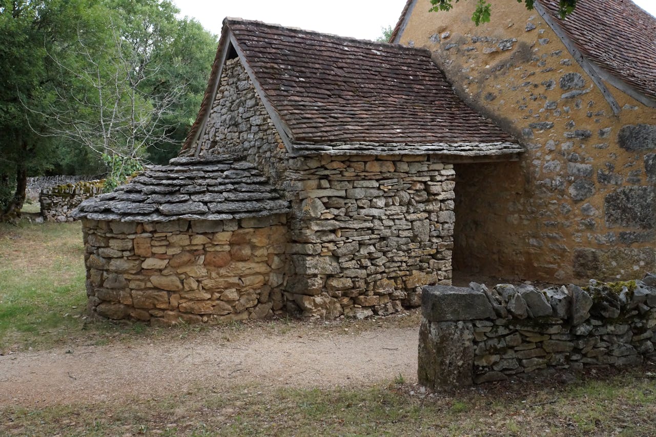Rustic stone house exterior in a peaceful rural countryside setting, showcasing traditional architecture.